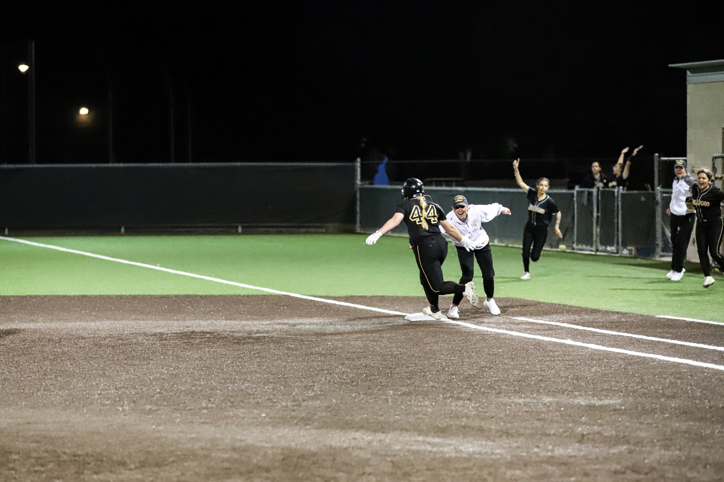 Kylee Jack celebrates with Coach Lockley following home run (photo by Bryce Hayes)
